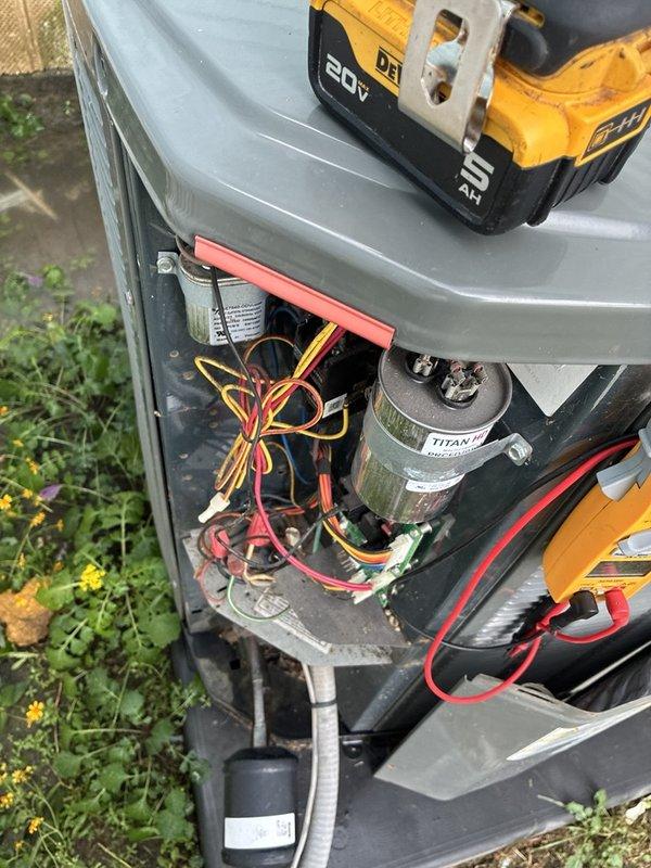 Responded to a no-operation call on a residential split system with an intermittent thermostat issue. Performed electrical diagnostics at the condenser control compartment, testing the run capacitor and associated low-voltage and line-voltage connections with a multimeter, and inspected the blower assembly, finding heavy dust and debris buildup on the motor housing and squirrel-cage wheel. System status and recommended repairs to be reviewed with the customer, including warranty coverage verification on the newer components.