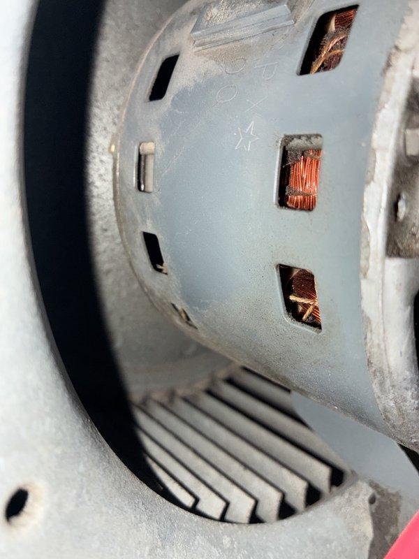Responded to a no-operation call on a residential split system with an intermittent thermostat issue. Performed electrical diagnostics at the condenser control compartment, testing the run capacitor and associated low-voltage and line-voltage connections with a multimeter, and inspected the blower assembly, finding heavy dust and debris buildup on the motor housing and squirrel-cage wheel. System status and recommended repairs to be reviewed with the customer, including warranty coverage verification on the newer components.