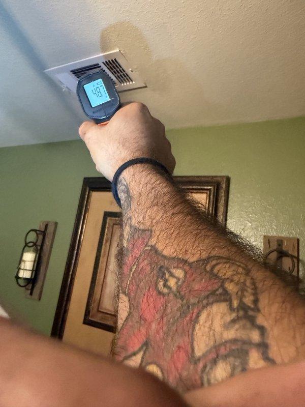 Responded to a warranty call for inadequate cooling in the spare bedroom and living room. Measured supply air temperatures at the ceiling registers with an infrared thermometer (readings of 48.7°F and 40.8°F), indicating uneven airflow and temperature distribution between zones. Noted water staining on the ceiling around the supply vent, suggesting possible condensation or a moisture issue in the duct system that warrants further inspection.