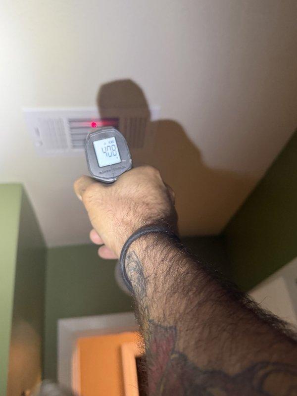 Responded to a warranty call for inadequate cooling in the spare bedroom and living room. Measured supply air temperatures at the ceiling registers with an infrared thermometer (readings of 48.7°F and 40.8°F), indicating uneven airflow and temperature distribution between zones. Noted water staining on the ceiling around the supply vent, suggesting possible condensation or a moisture issue in the duct system that warrants further inspection.