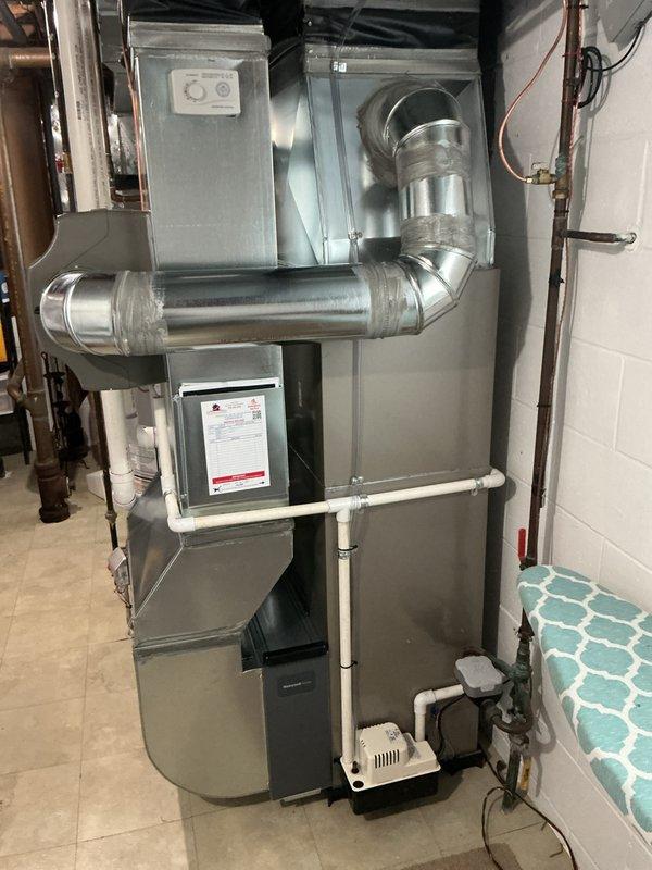 Successfully completed full system installation of a Bryant HVAC unit in utility room, featuring proper installation of metal ductwork with sealed joints, connection of PVC drain lines, and integration with existing plumbing. System includes furnace with upper and lower components, condensate pump, and all necessary connections for optimal airflow distribution throughout the residence.