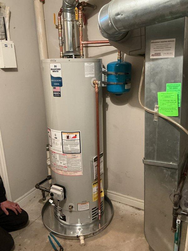 # Service Summary

Completed installation of a 40-gallon Bradford White natural gas automatic storage water heater with 40,000 BTU/hr input rating and 150 psi working pressure. Connected copper supply lines with brass fittings to the unit, installed thermal expansion tank, and integrated system with existing plumbing infrastructure. All safety labels, manufacturer specifications, and operational instructions are clearly visible on the unit, and installation meets code requirements for proper venting and clearances.