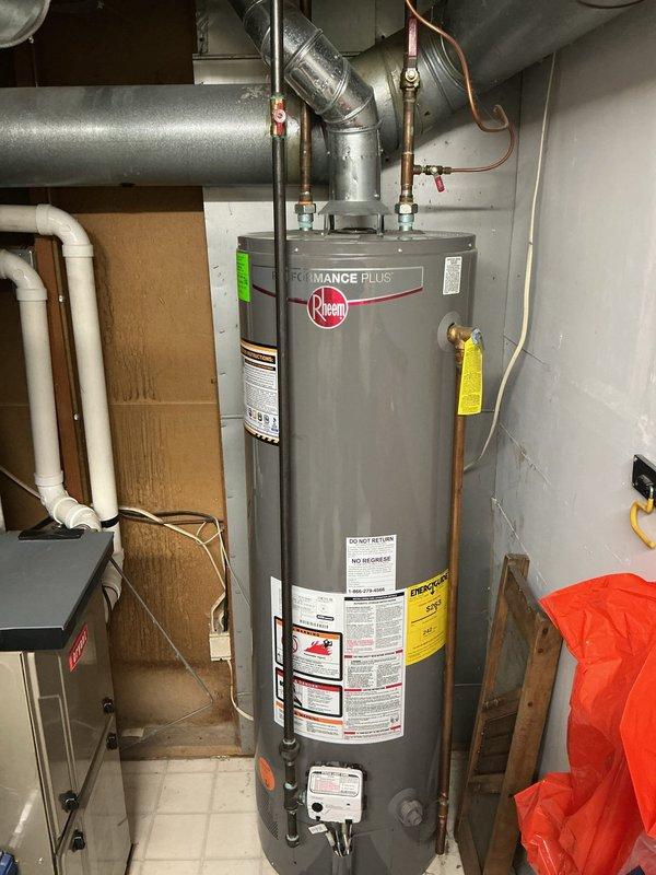 # Water Heater Replacement

Responded to service call for non-functional water heater in 10-year-old residential property. Upon inspection, determined existing unit had reached end of serviceable life at approximately 10 years of age. Removed and disposed of old water heater. Installed new Rheem Performance Plus residential water heater with proper venting configuration. Connected copper supply lines to hot and cold water ports with appropriate shut-off valves for future serviceability. Installed temperature and pressure relief valve per manufacturer specifications and code requirements. Configured metal exhaust ductwork to ensure proper ventilation of combustion gases. Verified all electrical connections to control components. Tested unit operation, confirmed proper heating function, and checked for leaks at all connection points. System restored to full operational status.