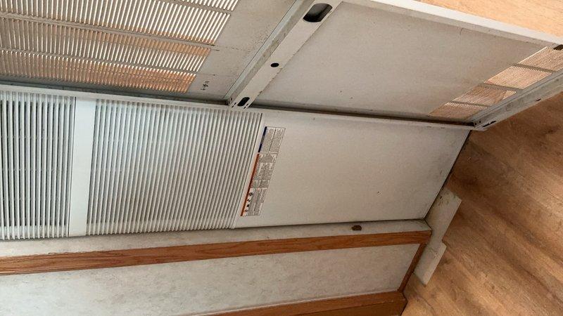 Completed preventive maintenance tune-up on 8kW standby generator using appropriate maintenance kit. Performed thorough inspection of furnace system in crawlspace due to reported banging and rattling noises during operation, examining all accessible components, mounting hardware, and ductwork connections. Documented HVAC system condition with photographs showing wall-mounted air handler unit with metallic heat exchanger fins and associated ductwork installation.