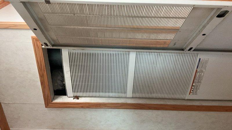 Completed preventive maintenance tune-up on 8kW standby generator using appropriate maintenance kit. Performed thorough inspection of furnace system in crawlspace due to reported banging and rattling noises during operation, examining all accessible components, mounting hardware, and ductwork connections. Documented HVAC system condition with photographs showing wall-mounted air handler unit with metallic heat exchanger fins and associated ductwork installation.