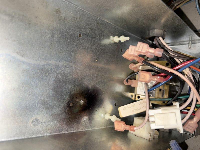 Responded to no heat call on 20-year-old gas furnace in mobile home. Upon inspection, discovered failed ignitor preventing proper furnace operation. Evidence of previous electrical arcing and heat damage observed on interior metal panel near ignitor assembly, with visible burn marks on galvanized surface. Diagnosed ignitor failure as primary cause of heating malfunction. Ordered universal replacement ignitor (Part # S1-03101932002) for installation. Documented electrical damage and circuit board condition through photographs. Return visit scheduled to complete ignitor replacement and restore heating functionality.