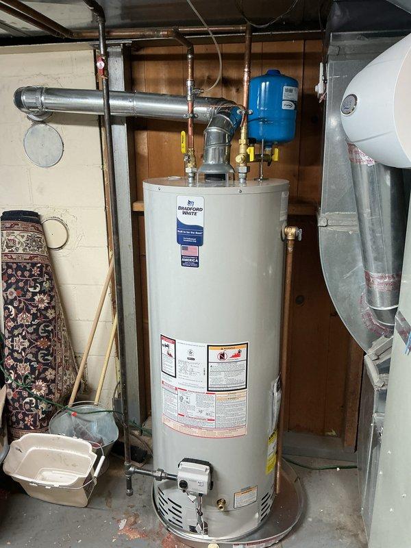 Installed a new Bradford White gas-fired water heater in basement utility area, including all necessary plumbing connections with copper piping and brass fittings at the unit's inlet and outlet. Configured proper venting system with metallic exhaust pipe, installed pressure relief valve with discharge piping, and integrated pressure tank into the system. Additionally, ran new gas piping from existing supply to accommodate outdoor grill installation, ensuring all connections meet code requirements and proper gas flow to both appliances.