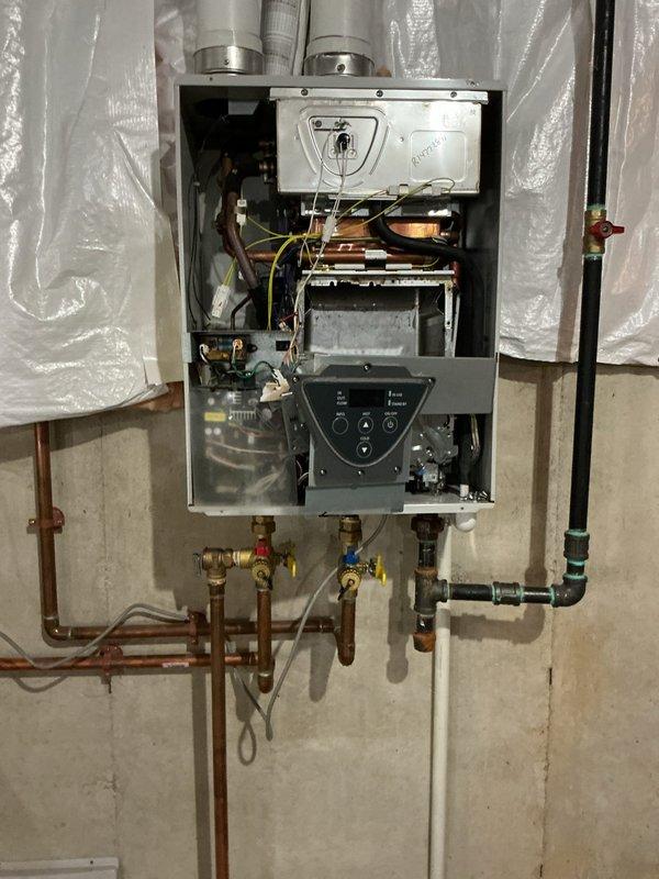 Responded to new customer service call for leaking tankless water heater. Upon arrival, performed diagnostic inspection of wall-mounted unit and identified source of water leak from internal components. Removed front access panel to examine heat exchanger assembly, copper piping connections, and pressure relief valves. Documented existing conditions showing signs of operational wear and confirmed active leak requiring repair. Assessed all plumbing connections, shut-off valves, and internal mechanical systems to determine extent of necessary repairs and provide customer with repair options for resolution.