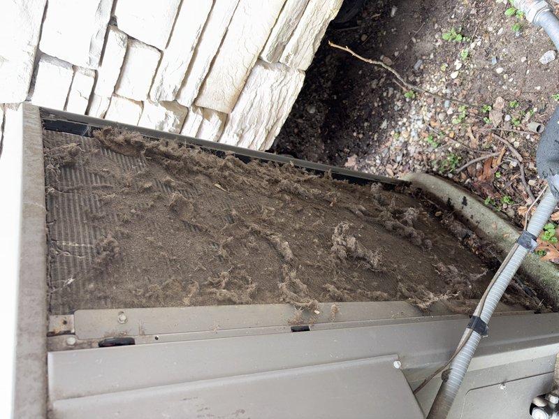 Completed spring AC tune-up on 1-year-old Lennox unit. Outdoor condenser showed heavy accumulation of dirt, leaves, and organic debris on top mesh grill and surrounding area. Performed comprehensive maintenance including cleaning condenser coil, inspecting refrigerant lines and connections, checking electrical components, and verifying proper system operation. All copper piping, brass fittings, and flexible conduit connections were inspected and found secure. System tested and confirmed working properly with no issues identified.