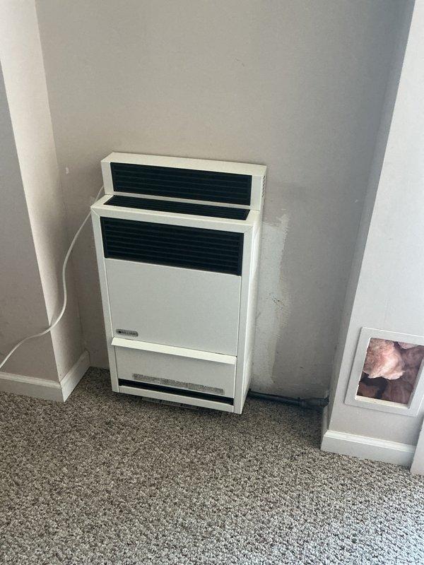 Completed removal and replacement of existing Williams wall furnace unit. Installed new wall furnace in corner alcove location with integrated blower kit for improved air circulation and heating efficiency. Mounted unit securely to wall structure, verified proper electrical connections, and routed power cord along baseboard for clean installation appearance. Confirmed exterior exhaust vent is properly sealed and functioning, with chrome vent cover mounted flush to exterior siding. Tested unit operation including ignition sequence, blower motor function, and thermostat response. Verified proper combustion air intake and exhaust ventilation. All safety controls and limit switches checked and operational. Unit heating effectively and cycling normally upon departure.