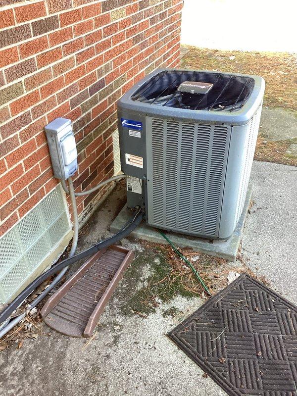 Performed routine gas furnace tune-up and system inspection at residential property. During inspection, discovered a compromised heat exchanger posing a safety hazard. Immediately tagged the unit "OUT OF SERVICE" and secured it to prevent operation until repairs can be completed. Inspected outdoor air conditioning condenser unit, confirmed proper placement on concrete pad, and verified electrical connections and conduit routing to wall-mounted disconnect box.