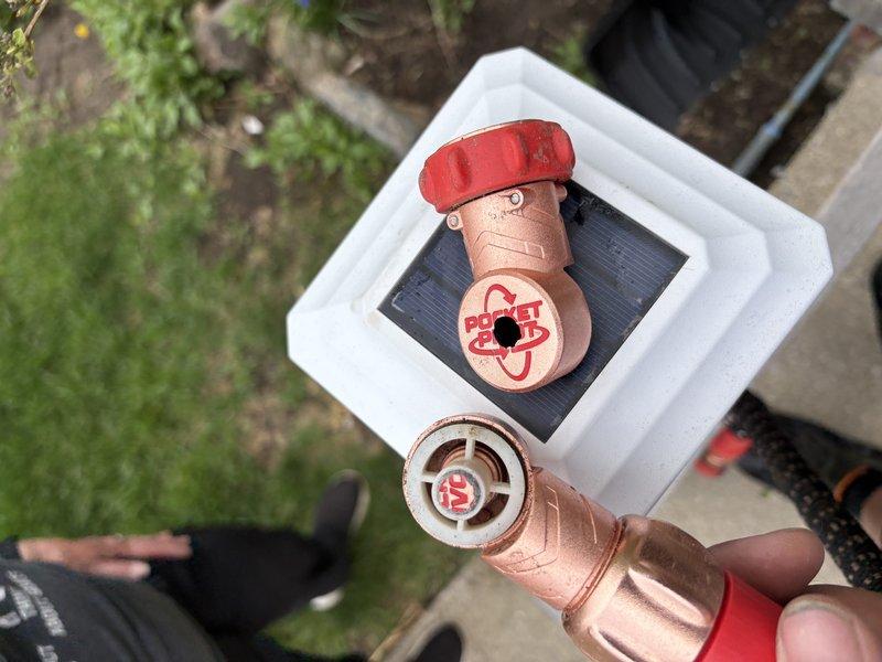 Completed system start-up and commissioning for newly installed air conditioning unit. Inspected outdoor condenser unit positioned on pad against exterior brick wall, verified proper installation of refrigerant lines, electrical connections, and drainage components. Identified damaged condensate drain hose, sourced replacement component featuring brass valve assembly with shutoff capability, and installed new hose to ensure proper system drainage and prevent water damage.