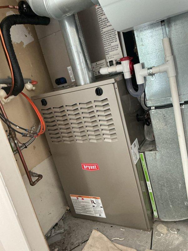 Completed installation of new Bryant air conditioning system with matching evaporator coil. Installed outdoor condensing unit on exterior pad with proper clearances, ran refrigerant lines and electrical connections to indoor coil mounted above existing furnace, established proper drainage through PVC piping, performed startup procedures, and verified system operation with proper airflow and temperature differential across the coil.