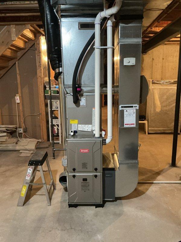 # HVAC Install - Complete System

Successfully completed full HVAC system installation in residential basement, including new Bryant furnace and air conditioning unit. The furnace was installed on the concrete basement floor with proper clearances and connected to new white PVC venting that runs vertically for exhaust and combustion air intake. Integrated the system with existing ductwork infrastructure, utilizing metal air handler housing positioned adjacent to the furnace unit.

Installed outdoor condensing unit (Model 134SAN03G00N, Serial 0G26X58641) with factory charge of 4.90 lbs refrigerant. Completed all refrigerant line connections using proper brazing techniques and verified system charge through service ports. Connected electrical components throughout the installation, routing wiring along basement framing in accordance with local electrical codes. Attached black flexible ductwork to complete air distribution pathway between furnace and existing duct system.

Performed syste