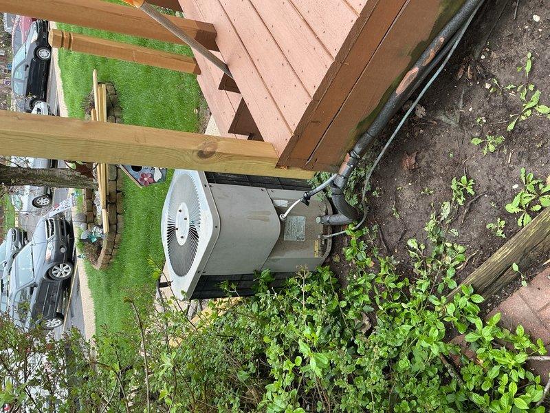 Responded to recurring annual freeze-up issue on residential air conditioning system. Upon arrival, inspected outdoor condensing unit and refrigerant lines for restrictions, debris buildup, and airflow obstructions. Evaluated system for potential causes including low refrigerant charge, restricted airflow, or mechanical failures contributing to coil icing. Documented equipment condition and installation location beneath elevated deck structure. System assessed and photographed for service records.