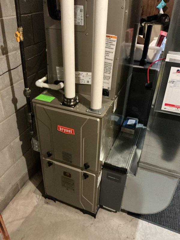 Completed full HVAC system installation including Bryant gas furnace, air conditioning unit, and air purification system in basement utility area. Installed and properly vented furnace with PVC intake and exhaust piping extending through exterior wall. Connected all electrical components, refrigerant lines, and ductwork to air handler. Mounted exterior condensing unit with appropriate line set routing along building exterior. Performed system start-up procedures, verified proper operation of all equipment, confirmed airflow and temperature differentials meet manufacturer specifications. All components tested and operating within normal parameters.