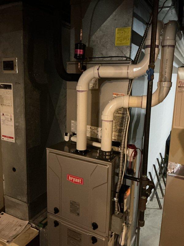 Completed installation of new Bryant air conditioning system with matching evaporator coil. Installed outdoor condensing unit on exterior pad adjacent to building, positioned alongside existing HVAC equipment with proper clearances maintained. Inside basement mechanical room, installed new evaporator coil on existing Bryant furnace, completed refrigerant line set connections using copper piping with proper insulation and secure wall mounting, ran condensate drainage lines, and installed all necessary electrical connections and controls. Verified proper system operation, refrigerant charge, and airflow upon startup.