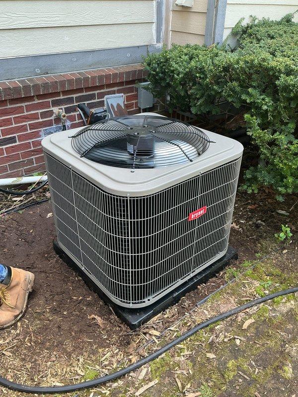 Completed installation of new air conditioning system including outdoor condenser unit and indoor evaporator coil. Outdoor unit was positioned on drain pan next to building foundation with proper clearance from structure and landscaping. Indoor evaporator coil was installed above existing furnace in basement mechanical room, integrated with existing ductwork system. All refrigerant lines were connected, system was charged to manufacturer specifications, electrical connections were completed, and unit was tested for proper operation and airflow.
