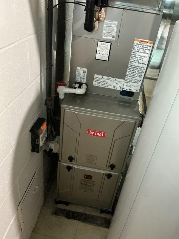 Completed air conditioning system start-up on newly installed Bryant HVAC system consisting of vertically stacked air handler and furnace unit in interior utility closet. Verified proper operation of all system components, confirmed condensate drain line functionality, checked refrigerant lines and electrical connections, and ensured exterior exhaust venting through PVC penetrations was properly sealed and operational.