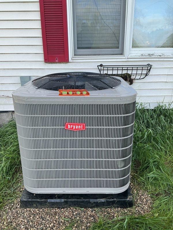 Responded to warranty call for Bryant condenser unit requiring re-leveling. Upon arrival, confirmed unit was sitting unevenly on gravel pad. Used torpedo level to verify unit was out of level, which can cause improper refrigerant flow, compressor strain, and reduced system efficiency. Re-leveled condenser unit on existing black base pad by adjusting gravel foundation beneath pad to achieve proper level in all directions. Verified unit stability and proper positioning. Unit now sits level and secure on gravel pad against exterior wall. All work completed under full warranty coverage.