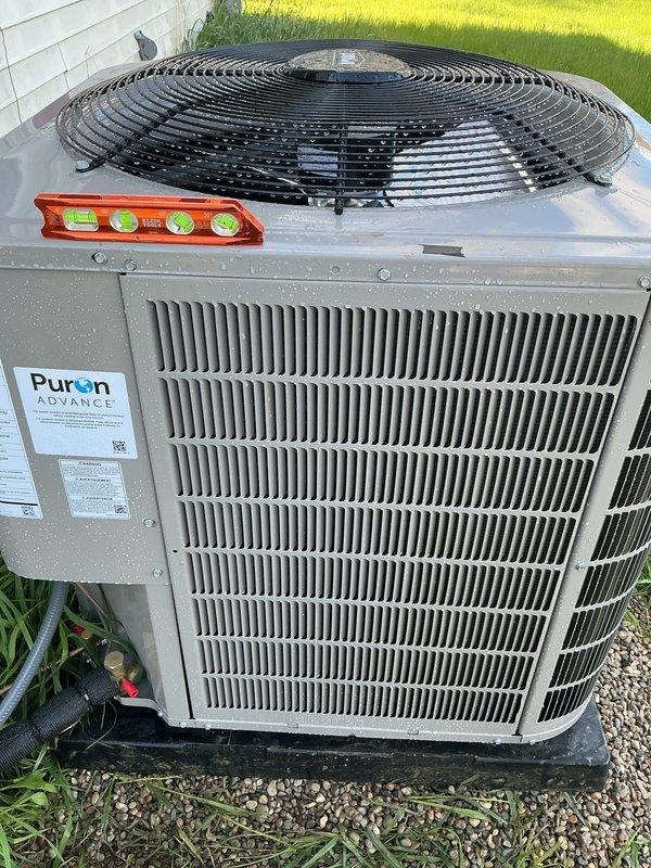 Responded to warranty call for Bryant condenser unit requiring re-leveling. Upon arrival, confirmed unit was sitting unevenly on gravel pad. Used torpedo level to verify unit was out of level, which can cause improper refrigerant flow, compressor strain, and reduced system efficiency. Re-leveled condenser unit on existing black base pad by adjusting gravel foundation beneath pad to achieve proper level in all directions. Verified unit stability and proper positioning. Unit now sits level and secure on gravel pad against exterior wall. All work completed under full warranty coverage.