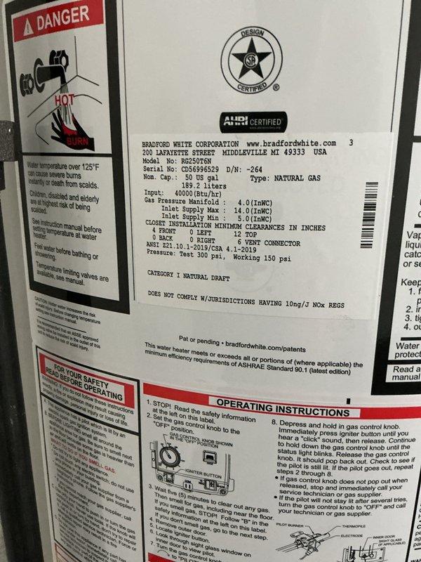Completed installation of a 50-gallon Bradford White natural gas water heater, model RE250T6N, with 40,000 BTU/hr input rating. The unit was properly positioned and secured in the basement utility area, with all gas connections, water supply lines, and venting configured according to manufacturer specifications and local code requirements. Copper supply piping was connected to ensure proper water flow, and the exhaust venting system was installed through the existing ductwork penetration in the wall structure. All safety labels and operational instructions remain visible and accessible on the unit for future reference.