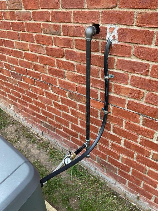 Completed installation of Honeywell residential generator system including exterior utility connections, gas line piping with proper mounting brackets and flexible conduit routing along brick exterior wall, electrical meter integration, and junction box installation. All components were professionally secured to building exterior with appropriate weatherproofing and code-compliant conduit work connecting gas service to generator location.