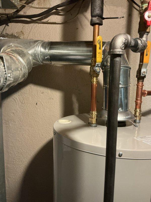 Completed installation of 5/8" tanked water heater in basement utility room. Connected all hot and cold water supply lines using copper piping with proper brass fittings and installed blue expansion tank on copper piping above unit. Installed pressure relief valve with discharge piping, verified all connections for proper seal, and confirmed system operational with no leaks detected.