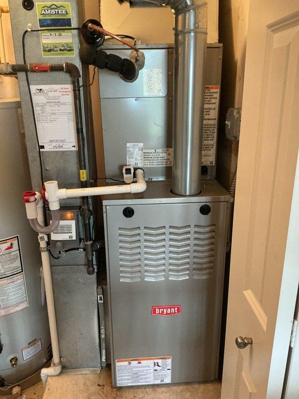 # HVAC System Installation

Successfully completed installation of a new Bryant furnace and air conditioning system. The indoor installation included mounting the furnace unit in the utility closet, connecting the evaporator coil assembly with refrigerant lines, and integrating the system with existing ductwork. All PVC drainage piping was properly routed and secured for condensate removal. The outdoor condensing unit was positioned on a ground-level pad against the exterior brick wall with appropriate clearance for airflow. Electrical connections were established through exterior junction boxes with conduit running to the unit. Refrigerant lines were run from the indoor coil to the outdoor condenser and the system was charged to manufacturer specifications. All connections were pressure tested for leaks and system operation was verified across heating and cooling modes. Equipment was left running efficiently with all safety controls functioning properly.