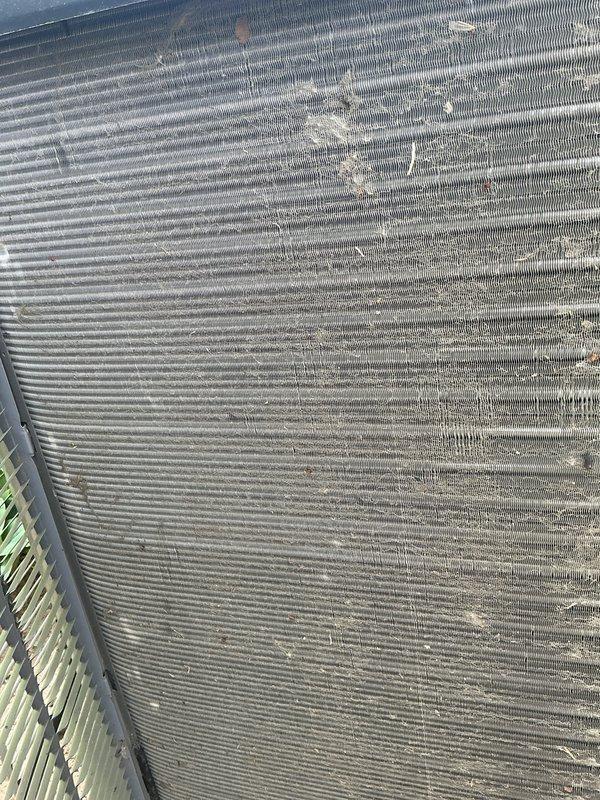 Completed comprehensive AC tune-up and maintenance service on a 2-year-old air conditioning system. Performed thorough inspection of outdoor condenser unit, which revealed significant accumulation of dirt, dust, and organic debris on condenser coils and unit base. Cleaned condenser coils to restore optimal heat transfer efficiency, removed debris buildup from base and surrounding areas, and verified system operation. All components tested and confirmed functioning properly upon completion.