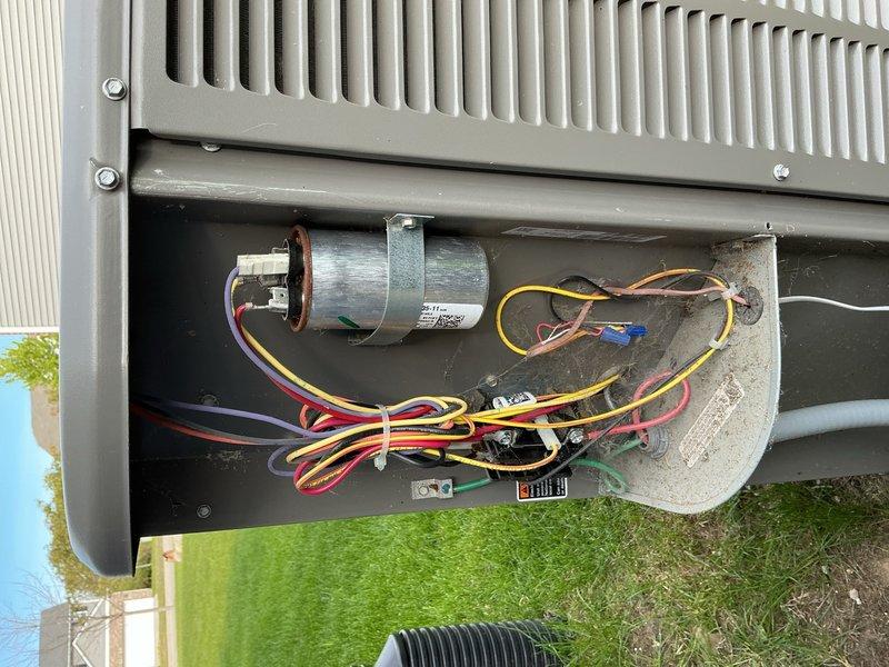 Completed comprehensive air conditioning tune-up on outdoor condensing unit positioned on artificial turf beside building. Performed standard maintenance protocol including inspection of compressor, capacitor, electrical connections, and control components; verified proper wire routing and connections; cleaned condenser coils; checked refrigerant lines; and confirmed unit operational status. Customer reinstated preventative maintenance membership program during this service visit.
