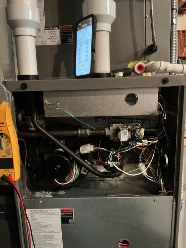 Completed comprehensive HVAC maintenance service including air conditioning and gas furnace tune-ups as part of membership renewal. Performed thorough inspection of furnace unit with access panel removed, examining blower motor assemblies, electrical connections, and internal components. Verified proper operation of dual blower motors and checked all wire connections including ground wires. Inspected condensate drain lines and PVC venting system for proper drainage and clearance. Conducted diagnostic testing using multimeter to verify electrical performance and system functionality. Examined basement mechanical room installation including heating system, galvanized exhaust venting, and PVC piping manifold at base of unit. Verified electrical conduit and disconnect switch installation. All systems operating within normal parameters upon completion of preventative maintenance service.