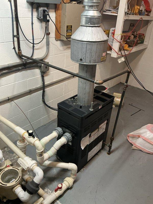 Completed comprehensive HVAC maintenance service including air conditioning and gas furnace tune-ups as part of membership renewal. Performed thorough inspection of furnace unit with access panel removed, examining blower motor assemblies, electrical connections, and internal components. Verified proper operation of dual blower motors and checked all wire connections including ground wires. Inspected condensate drain lines and PVC venting system for proper drainage and clearance. Conducted diagnostic testing using multimeter to verify electrical performance and system functionality. Examined basement mechanical room installation including heating system, galvanized exhaust venting, and PVC piping manifold at base of unit. Verified electrical conduit and disconnect switch installation. All systems operating within normal parameters upon completion of preventative maintenance service.