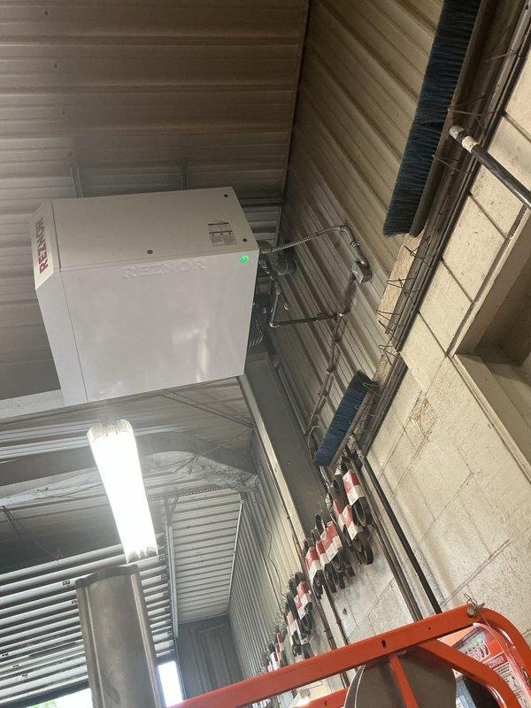 Successfully installed a Reznor overhead unit heater in the mechanical room, mounting the equipment to the ceiling structure with proper brackets and hardware. The installation included all necessary electrical connections, venting, and gas piping, with the unit now operational as indicated by the green status light on the control panel.