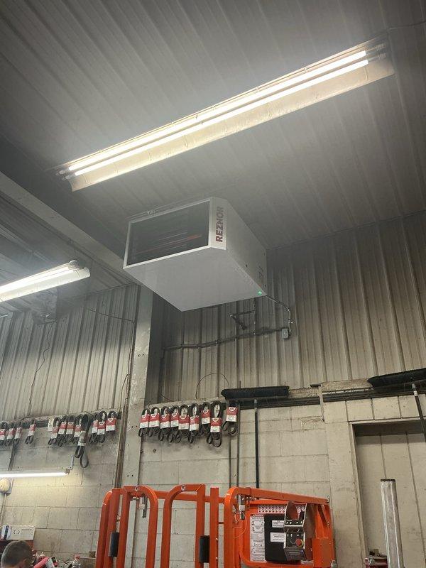 Successfully installed a Reznor overhead unit heater in the mechanical room, mounting the equipment to the ceiling structure with proper brackets and hardware. The installation included all necessary electrical connections, venting, and gas piping, with the unit now operational as indicated by the green status light on the control panel.
