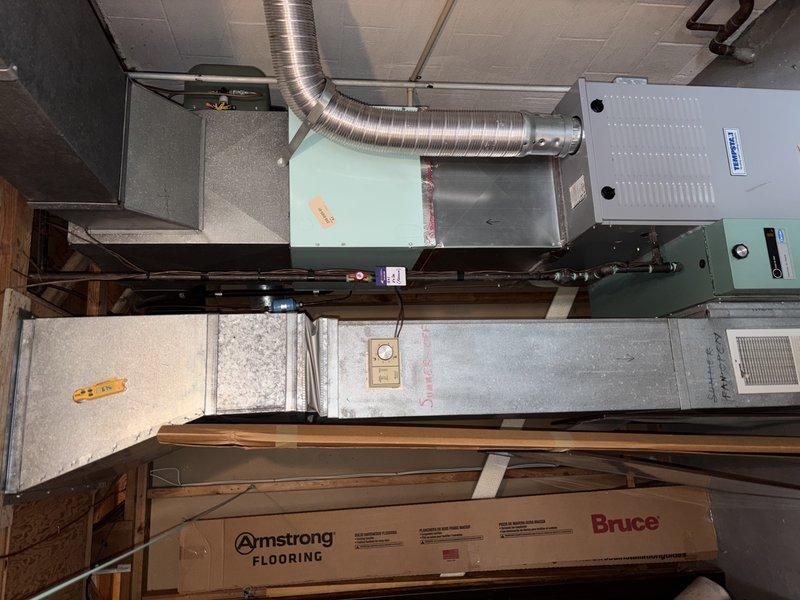 Responded to service call for non-functional humidifier system. Upon inspection, found humidifier unit severely rusted and inoperable, requiring replacement. Documented existing HVAC system configuration including furnace, evaporator coil, and ductwork connections for service records.