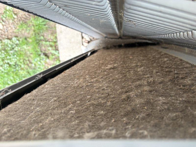 Responded to recall for air conditioning system not operating. Upon arrival, found outdoor unit equipped with heavily contaminated filter media showing significant dust and debris accumulation across entire surface. Filter restriction was preventing proper airflow through condenser coil, causing system failure. Removed and replaced dirty filter with new media. Verified condenser coil fins were intact and undamaged beneath filter assembly. Restored unit to proper operating condition with adequate airflow. System tested and confirmed cooling operation restored.