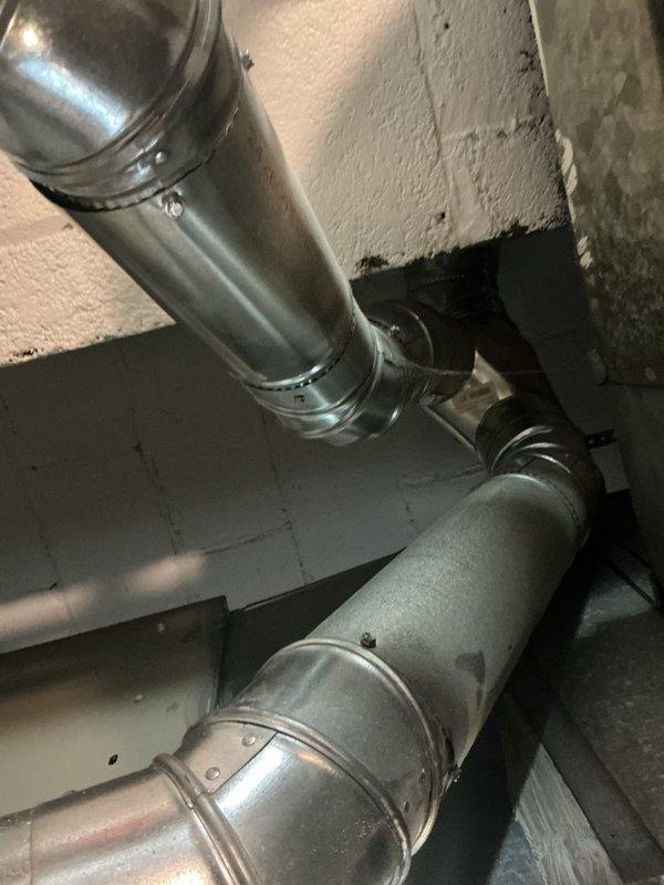 Completed installation of new air conditioning system and evaporator coil in residential property. Connected ductwork at attic junction point with proper sealing and secured all connections with metal bands per manufacturer specifications. System tested and verified operational with proper airflow throughout distribution system.
