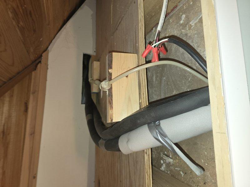 Responded to service call for 9-year-old mini split system experiencing condensate drain line malfunction that resulted in backup and ceiling damage. Upon inspection, identified clogged condensate line causing water to overflow through emergency drain pan. Cleared blockage from primary drain line and verified proper drainage flow. Rerouted and secured condensate piping through wall framing using appropriate hangers and insulation to prevent future issues. Tested system operation in cooling mode to confirm condensate removal functioning correctly with no leaks or backup. System restored to full operational capacity with proper drainage established.
