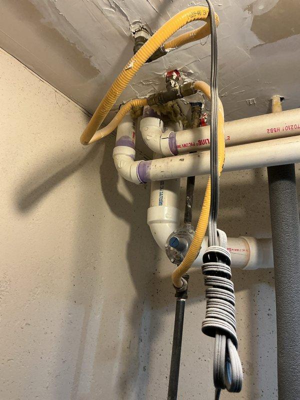 Completed installation of new gas furnace system including all required venting and condensate drainage components. Installed white PVC venting system with proper joints and supports, connected yellow flexible gas line to unit, and established condensate drain piping with shutoff valves for system maintenance access. Mounted and secured furnace unit, verified all connections meet code requirements, and affixed manufacturer's energy efficiency labeling to equipment.