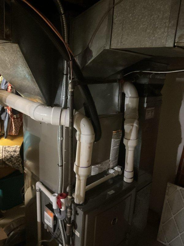 Completed full HVAC system installation including new air conditioning unit and evaporator coil. Installed outdoor condenser unit on concrete pad with proper electrical disconnect and refrigerant line connections. Mounted indoor air handler with evaporator coil in basement utility area between floor joists, integrated with existing furnace system. Ran refrigerant lines from outdoor unit to indoor coil, installed PVC condensate drainage system with proper trap and termination, and connected all necessary ductwork including supply and return air pathways. Verified all electrical connections, tested system operation, and confirmed proper refrigerant charge and airflow. Installation completed per manufacturer specifications with all components properly secured and operational.