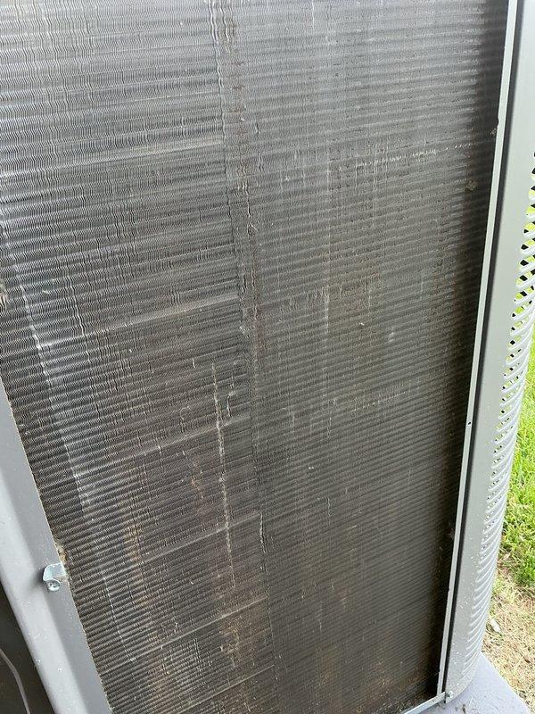 Completed routine air conditioning tune-up and regular maintenance on outdoor condensing unit. Visual inspection revealed heavily soiled condenser coils with significant dirt and debris accumulation affecting airflow efficiency, along with minor fin damage observed on exterior panels. Unit serviced and returned to operational status.