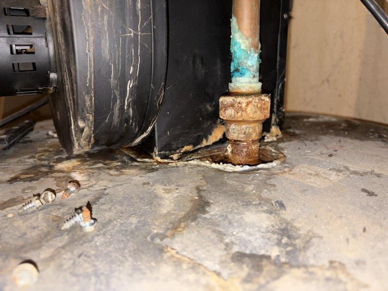 Responded to emergency service call for no hot water and leaking tank. Upon arrival, performed comprehensive assessment of existing tanked water heater system. Inspection revealed active leak at tank with visible water damage on concrete floor beneath unit. Observed significant corrosion on copper supply piping with turquoise-blue oxidation on upper portions and heavy brownish-orange corrosion on brass fittings and connection points. Multiple connection points showed advanced deterioration consistent with age and moisture exposure. Documented tank failure and associated plumbing infrastructure damage through photographic evidence. Tank deemed non-repairable due to extent of leak and overall condition. Provided assessment findings and recommended complete water heater replacement. Customer approved replacement recommendation with understanding that installation would be scheduled after holiday period. Secured work area and ensured no further water damage would occur pending replacement 