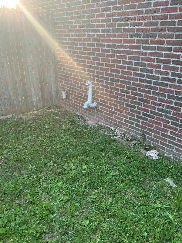 Completed full HVAC system installation including new furnace and air conditioning unit at residential property. Installed outdoor condensing unit on exterior pad adjacent to brick wall with proper clearances, ran refrigerant lines and electrical connections, and set up condensate drainage system using PVC piping. Interior installation included furnace placement in basement/utility area with associated ductwork connections, gas line hookup, electrical wiring, and condensate pump installation for proper drainage management.