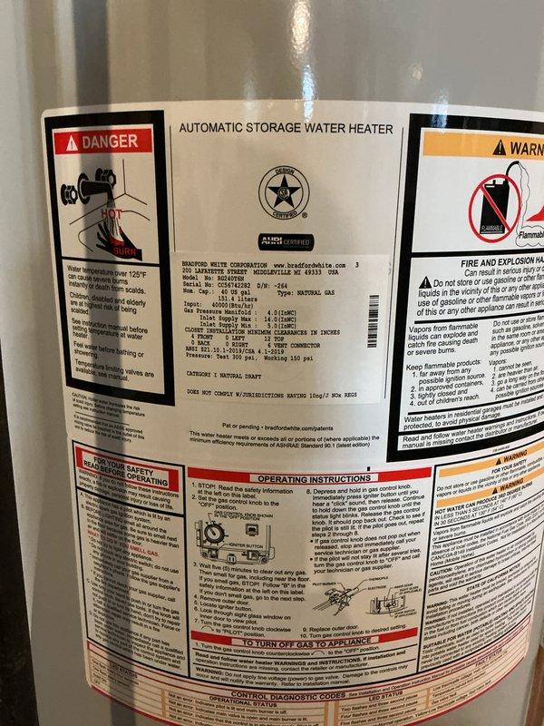 Completed installation of a new automatic storage gas water heater. The unit was properly positioned on a concrete floor with all manufacturer specifications, safety labels, and warning decals intact and visible. Connected gas supply line, installed draft hood assembly, and verified proper venting. Mounted condensate pump assembly at the base of the unit with appropriate electrical connections and discharge piping. All connections were tested for leaks, pilot was lit, and burner operation was confirmed. Unit is functioning properly and ready for service.