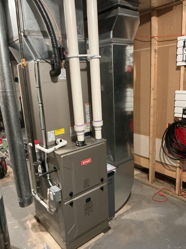 Completed full HVAC system installation including Bryant furnace unit with proper venting configuration utilizing dual white PVC intake and exhaust pipes. Installed galvanized steel ductwork with appropriate electrical conduit connections, ensuring all equipment clearances meet manufacturer specifications and code requirements in basement utility space.