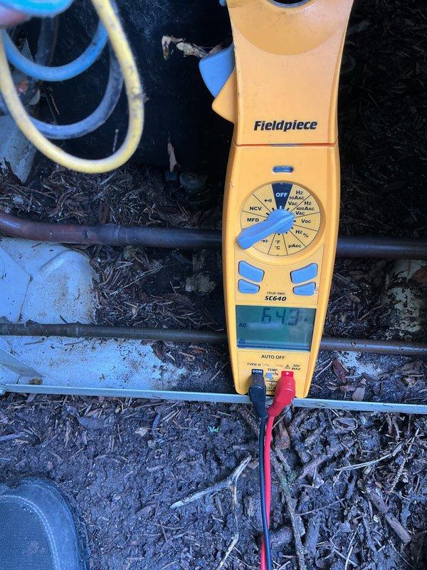 Completed preventive maintenance tune-up on older Bryant air conditioning condenser unit. Performed standard diagnostic testing including electrical measurements, with amperage readings documented at 642.7 amps using clamp meter during system operation. Unit operational at time of service completion.