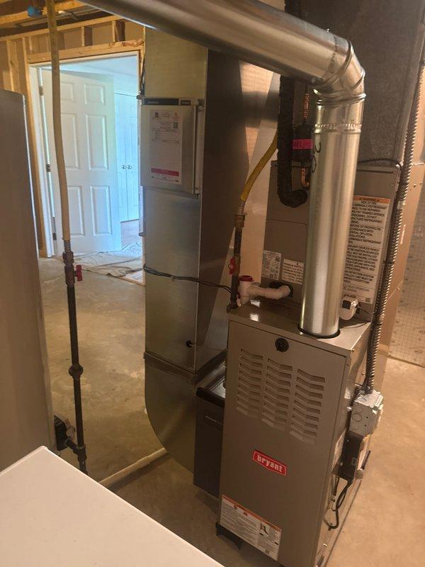 Completed full HVAC system installation in residential basement utility room, including new gas furnace with proper venting and ductwork connections, air handler with flexible metal ducting distribution, and integrated water heater. All equipment properly mounted with appropriate clearances, gas line connections secured, electrical components wired to panel with indicator lights operational, and system tested for safe operation. Installation meets code requirements with organized routing of all ductwork, piping, and conduits throughout the mechanical space.