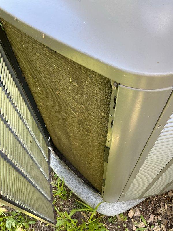Completed preventive maintenance inspection on four split-system air conditioning units. Documented condition of outdoor condenser units, noting heavily soiled air filters with significant dust and debris accumulation, vegetation growth around unit bases requiring clearance, and weathered exterior housings with minor surface discoloration from environmental exposure. Removed access panels to assess internal components including heat exchanger coils and filtration systems, capturing photographic documentation of maintenance needs for customer records.