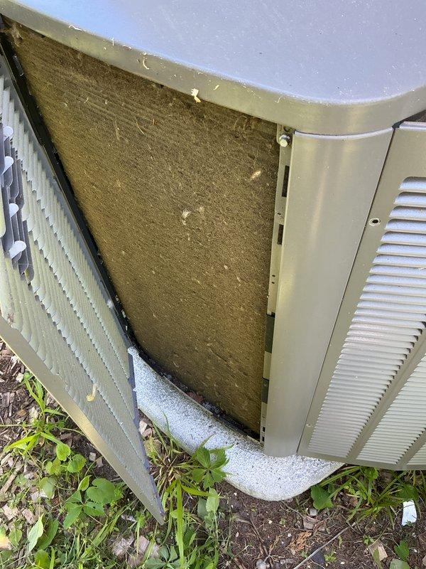 Completed preventive maintenance inspection on four split-system air conditioning units. Documented condition of outdoor condenser units, noting heavily soiled air filters with significant dust and debris accumulation, vegetation growth around unit bases requiring clearance, and weathered exterior housings with minor surface discoloration from environmental exposure. Removed access panels to assess internal components including heat exchanger coils and filtration systems, capturing photographic documentation of maintenance needs for customer records.